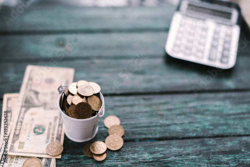 Cuadro en lienzo Calculator with money and pennies on a wooden green background