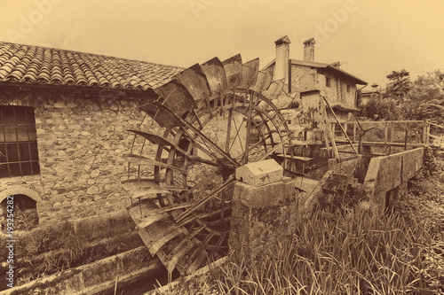 Old water wheels of a watermill. Vintage style picture. Adding grain to give an old photo effect.
