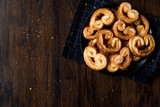 Palmier Cookies in Black Plate on Wooden Surface.
