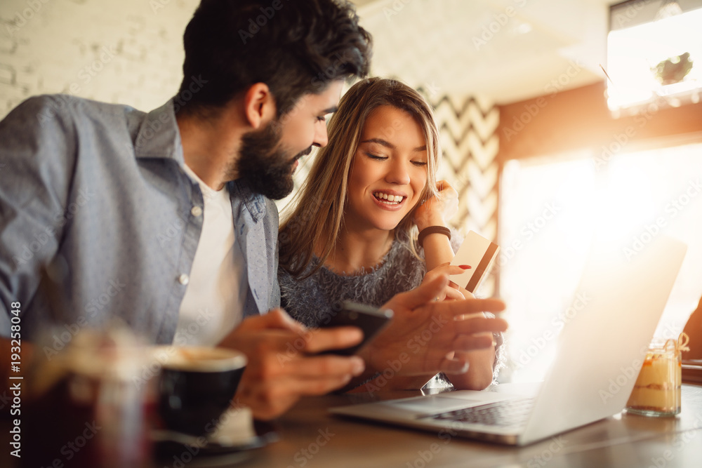 Young couple shopping online on laptop.