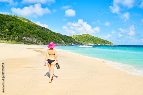 A woman tourist on tropical Beach Police Bay (white sand and turquoise sea) , south of Mahe, Seychelles © LR Photographies