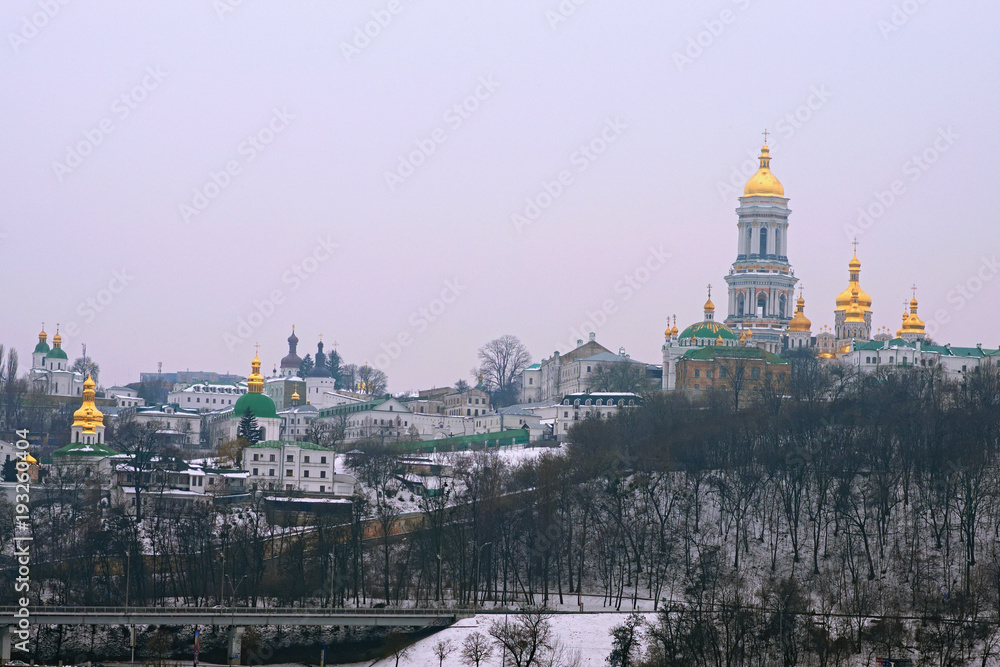 Famous Kyievo-Pechers'ka lavra and Belltower on blue sky background. It is a historic Orthodox Christian monastery. Morning landscape photo. Foggy winter landscape, Kyiv, Ukraine