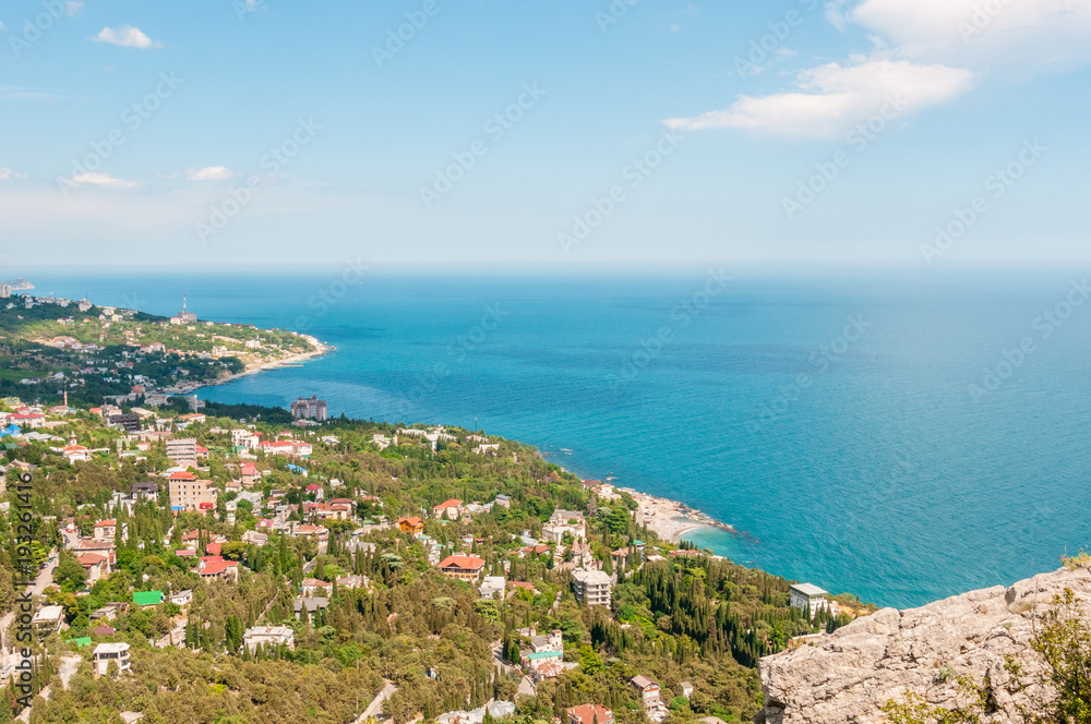Beach at the seaside, blue water, view from above the mountains to the town of Simeiz, Yalta, Crimea