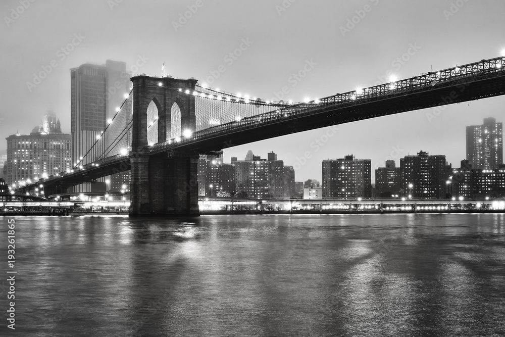 Brooklyn Bridge and the Manhattan on a foggy night, New York City, USA.