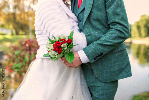 bride holding wedding bouquet and groom