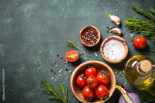 Food cooking ingredients on dark stone table.