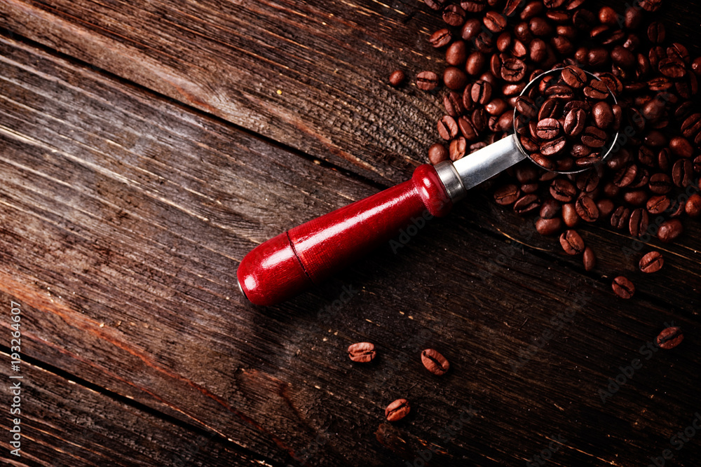 kaffeebohnen mit rustikalen löffel auf holz
