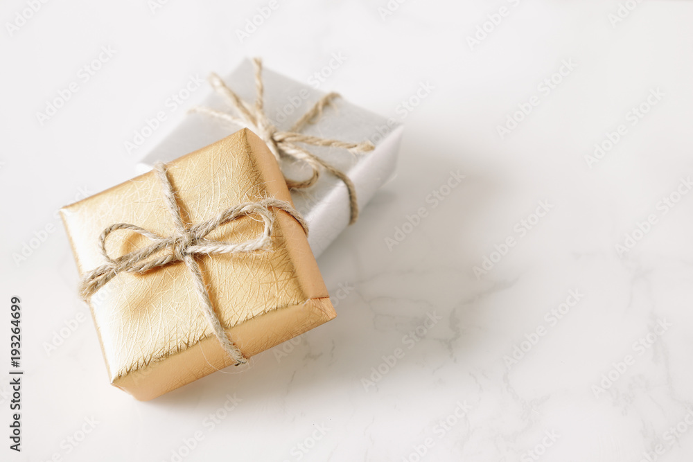 Gold and silver gift on white stone table Gold and silver gift on white stone table