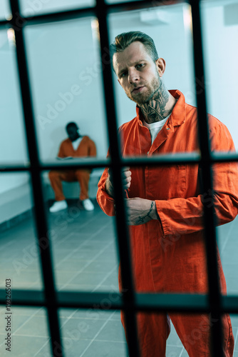 multiethnic criminals in prison cell behind prison bars
