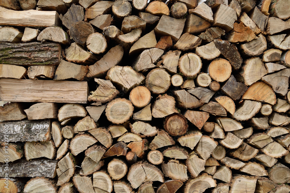 A lot of dry chopped firewood is stacked in the period of preparation for the furnace chopped logs for winter fire A lot of dry chopped firewood is stacked in the period of preparation for the furnace chopped logs for winter fire