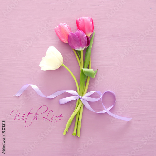 bouquet of pink and white tulips over white wooden background. Top view.