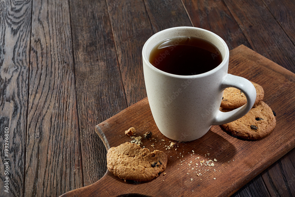 Cup of tea with cookies, workbook and a pencil on a wooden background, top view Cup of tea with cookies, workbook and a pencil on a wooden background, top view