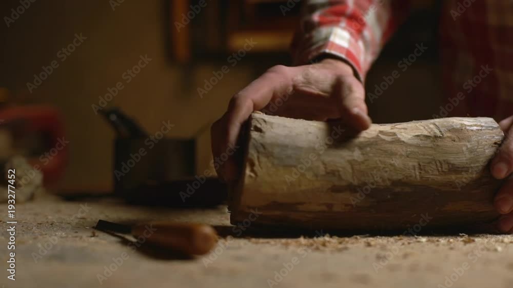 Portrait cropped of male specialist doing carpentry on handmade wood manufacture, and working with log in woodshop slow motion Portrait cropped of male specialist doing carpentry on handmade wood manufacture, and working with log in woodshop slow motion