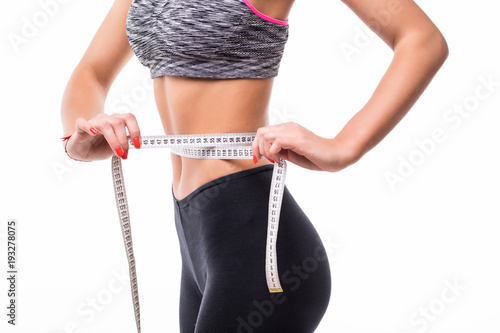 Fitness Woman in sport bra measuring her body with tape isolated on white