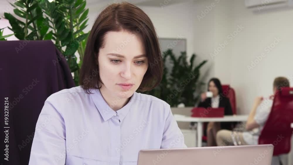 Business woman working on laptop and drinking coffee in the office Business woman working on laptop and drinking coffee in the office