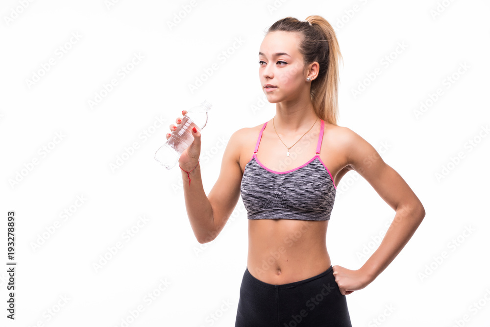 Young woman in fitness wear drinking iolated over white Young woman in fitness wear drinking iolated over white