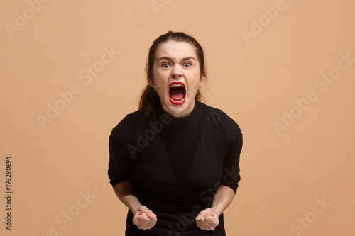 The young emotional angry woman screaming on pastel studio background photo