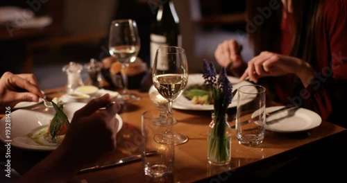 4K Unrecognizable couple on a date in restaurant chatting as they enjoy their meal
