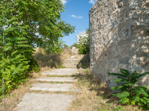 Stone stairs alongside of rocky walls of an ancient fortress in summer