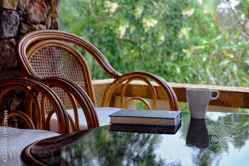 Wallpaper Mural Wicker chair on balcony, cup of coffee and book. Concept calmness, meditation, old age, downshifting. Thailand Torontodigital.ca