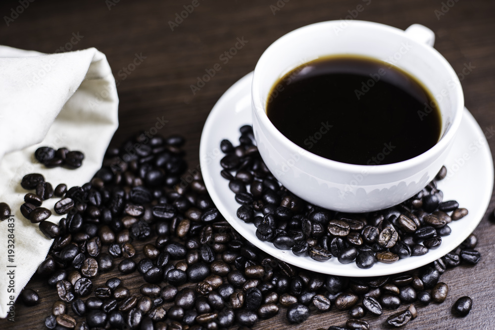 Black coffee in cup and coffee bean and bag on wood background. Black coffee in cup and coffee bean and bag on wood background.