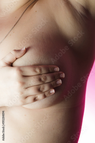 Woman with hands on breasts on a pink background / Outubro Rosa