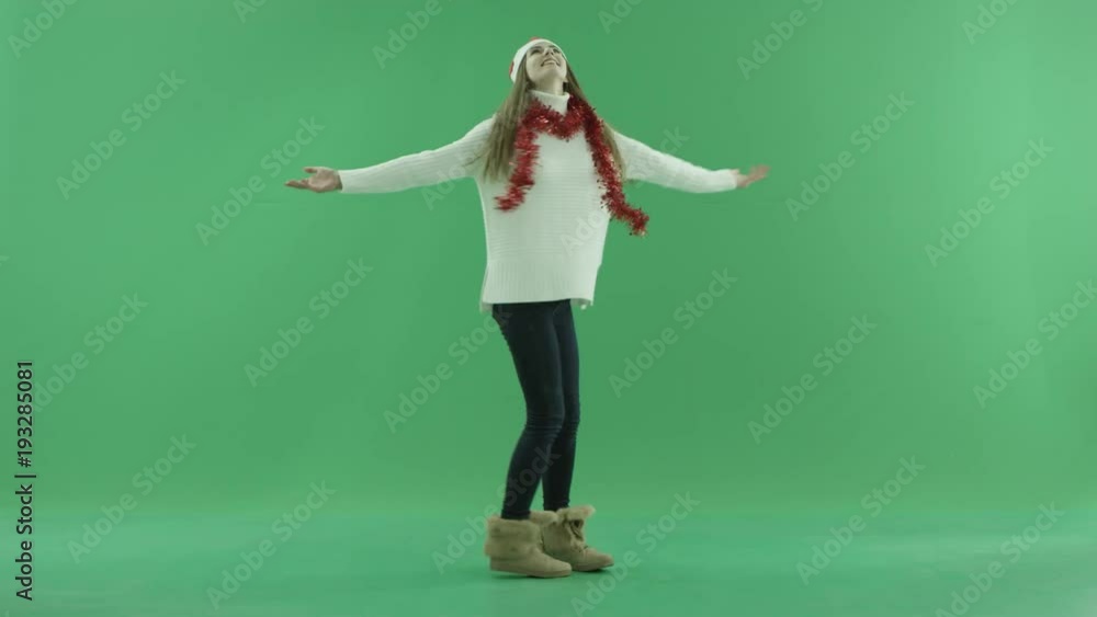 Gorgeous female in Christmas hat enjoys snowfall, chroma key on background Gorgeous female in Christmas hat enjoys snowfall, chroma key on background