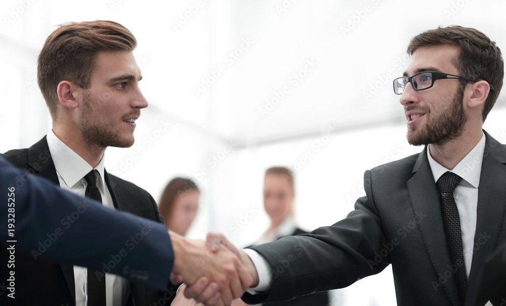 Partners concluding deal and shaking hands in the presence of team members