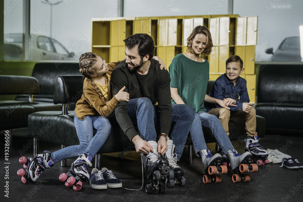 Fototapeta premium family resting on sofa before skating in roller skates in skate park