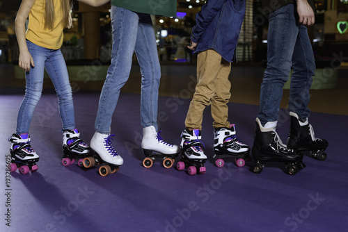 partial view of parents and kids skating on roller rink together photo