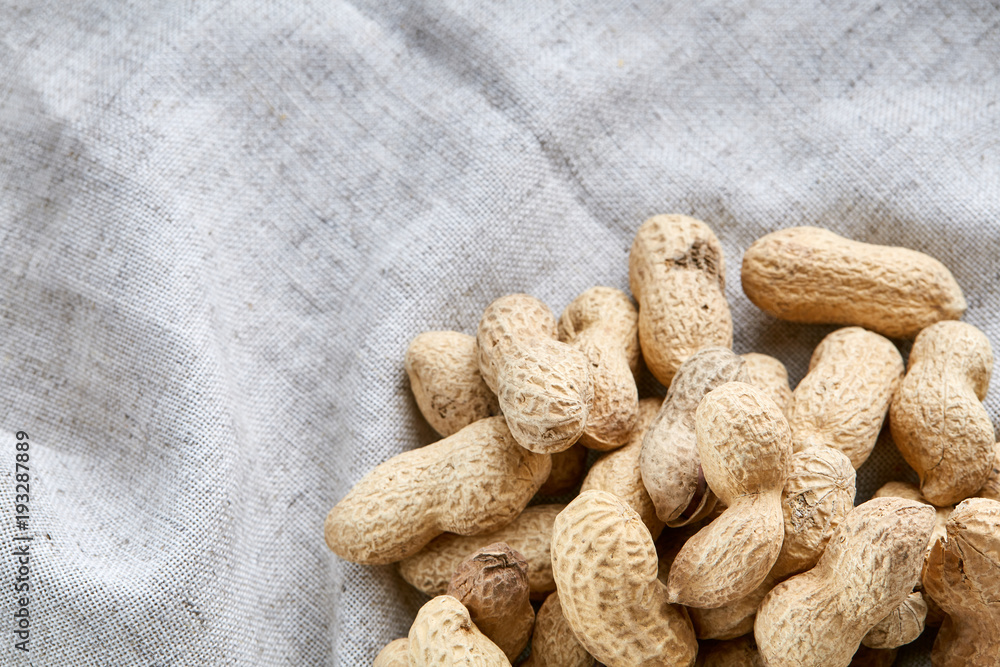 Heap of peanuts on light tablecloth, close-up, shallow depth of field, selective focus, macro Heap of peanuts on light tablecloth, close-up, shallow depth of field, selective focus, macro