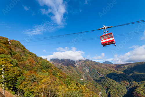 Red cable cars riding to Akechidaira observation deck with beautiful autumn season colors, Nikko, Japan.
