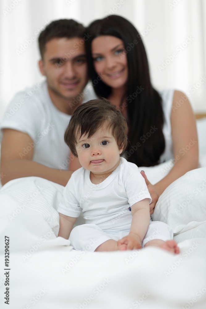 Happy couple and son sitting in bed Happy couple and son sitting in bed