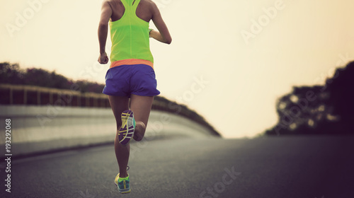 young fitness asian woman runner running on city road © lzf