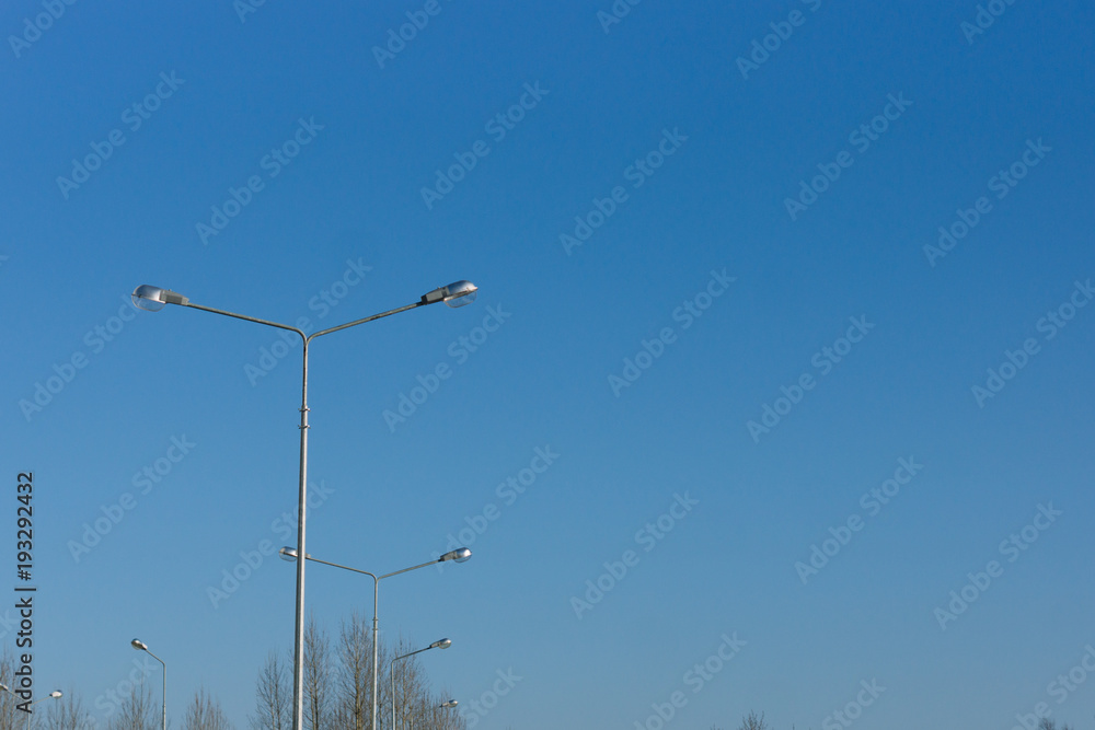 Lampposts on blue sky background. Space for text