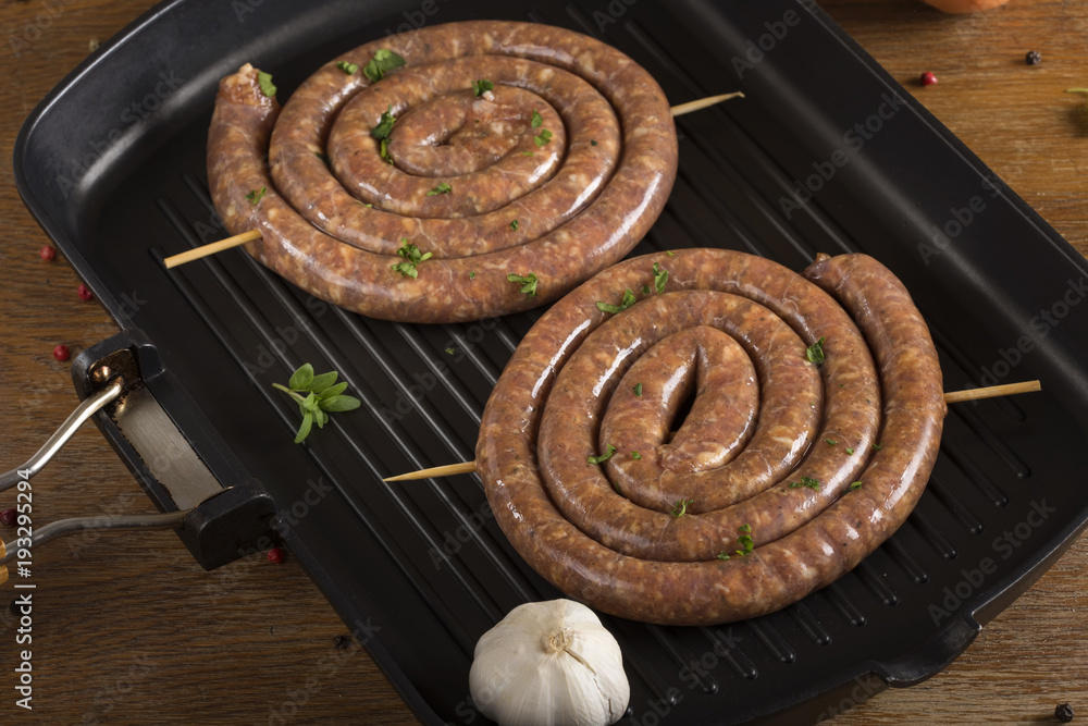 Grill pan with delicious sausages and herbs Grill pan with delicious sausages and herbs