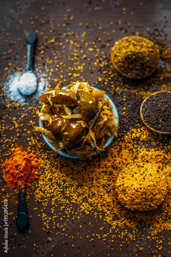 Popular Indian cabbage pickle with all spices and other vegetable i.e chili on a wooden surface in dark Gothic colors. photo