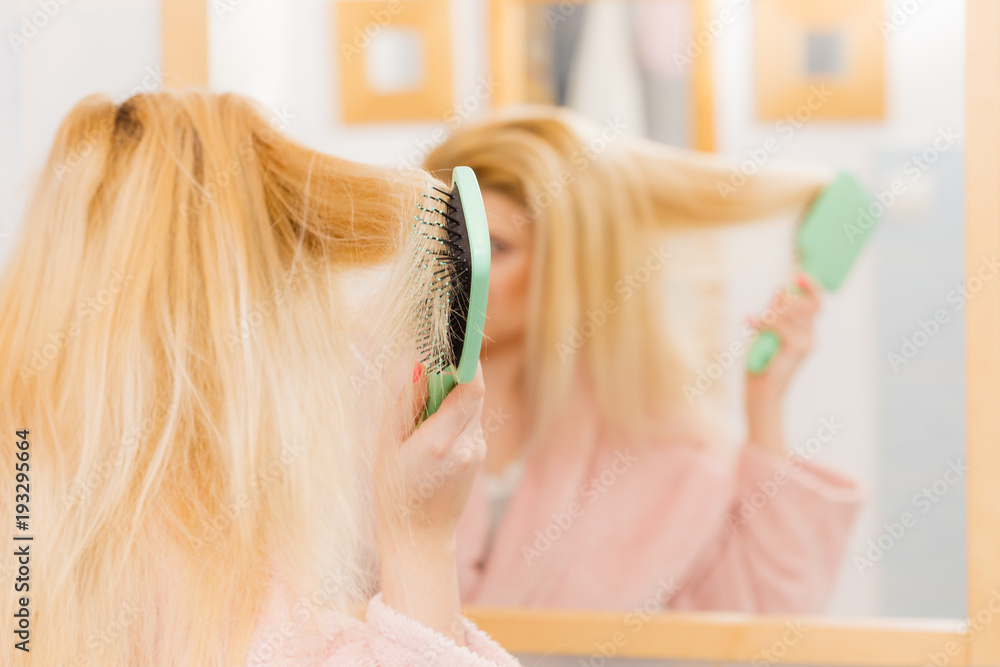 Fototapeta premium Woman wearing dressing gown brushing her hair