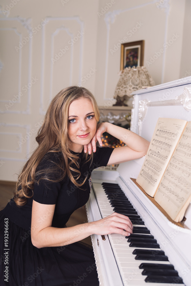 young blond woman play no white piano young blond woman play no white piano