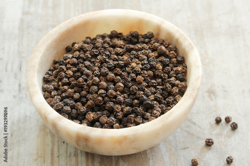 Whole Black Pepper in a marble bowl ,still life selective focus Whole Black Pepper in a marble bowl ,still life selective focus