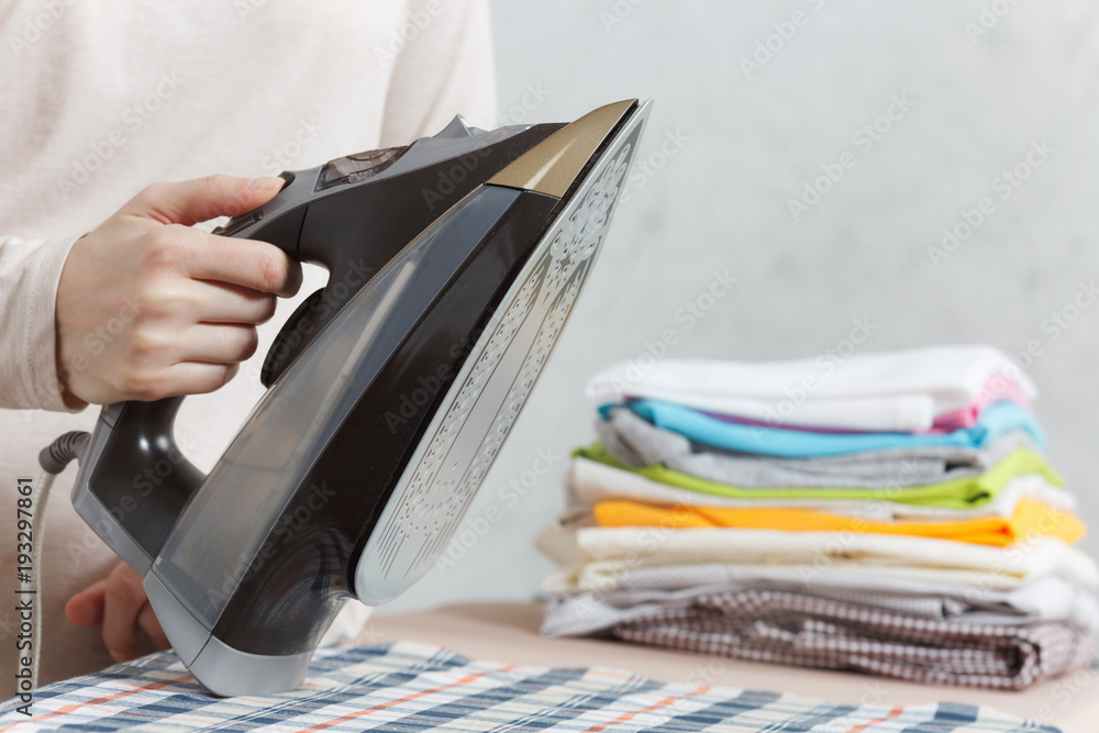 custom made wallpaper toronto digitalClose up cropped photo woman hand holding iron. Housewife in light clothes ironing checkered shirt, clothing on ironing board with iron. Housekeeping concept. Copy space for advertisement.