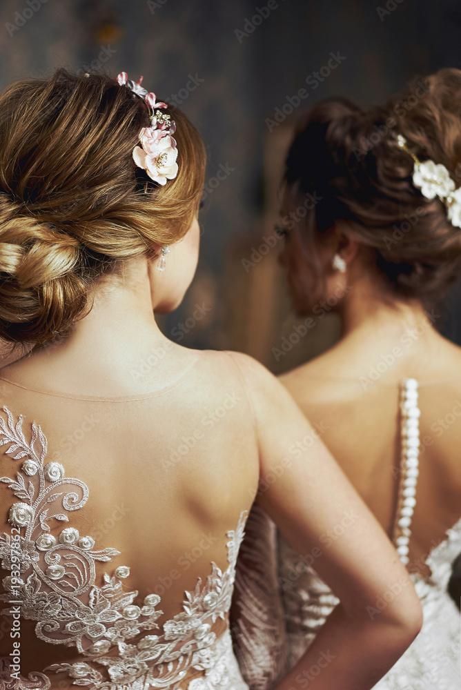 Two girls in wedding dresses. Beautiful delicate girls in the Bridal salon. Close-up