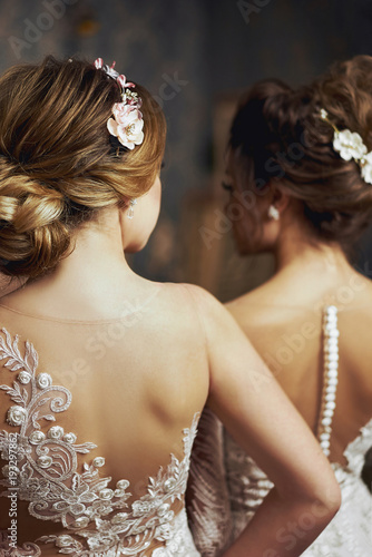 Two girls in wedding dresses. Beautiful delicate girls in the Bridal salon. Close-up