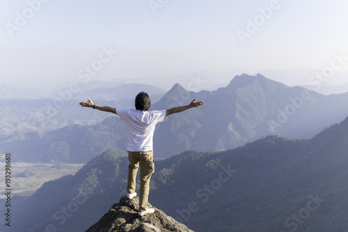 Man standing on the mountain and enjoying beautiful view on mountains. Freedom concept