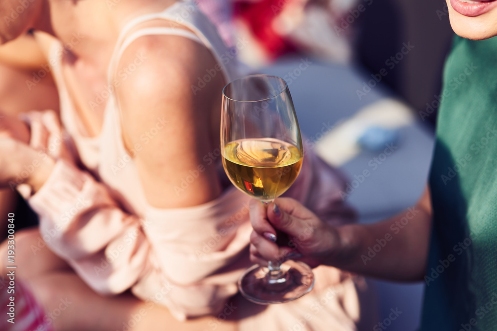 Close up of wineglass in hands of young nice woman