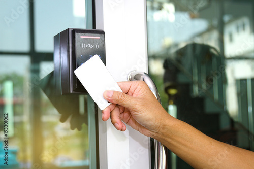 Close-up hand inserting keycard to lock and unlock door 