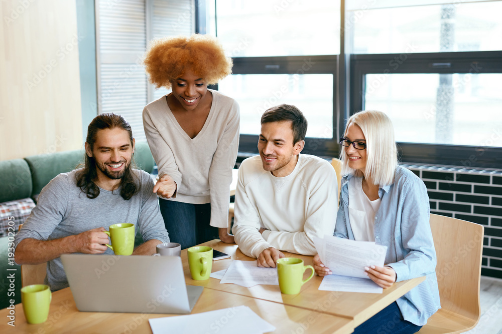 Obraz premium Friends Working Together At Cafe, Using Computer