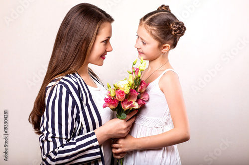 daughter gives her mother flowers in the studio, happy mother's day