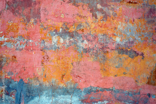 Bare concrete wall, peeling paint, pink and orange.