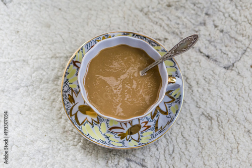 Closing a glass of freshly brewed coffee to an old white rustic table. Little depth of focus. Concept nostalgia.